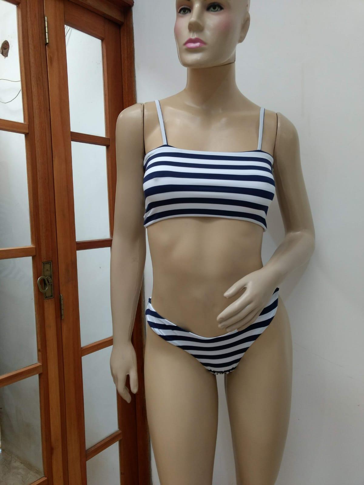 Manequim usando um biquíni listrado em branco e azul marinho